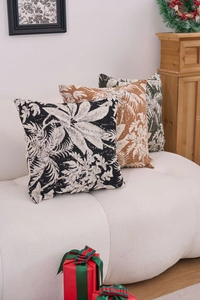 Detail of chenille jacquard square pillow covers with tropical leaf patterns on a sofa