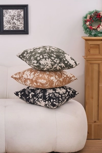 Close-up of three chenille jacquard pillows with floral patterns on a cozy white sofa