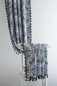 Detail of vintage black damask pattern on semi-shading fabric with elegant tassel trim