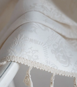 Close-up of vintage relief floral jacquard fabric with elegant tassel fringe detail