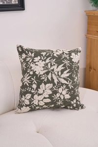 Detailed close-up of dark green chenille pillow with cream floral jacquard pattern