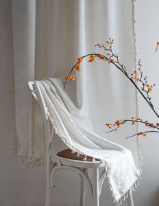 Detail of French vintage cream floral jacquard curtain fabric with decorative tassels
