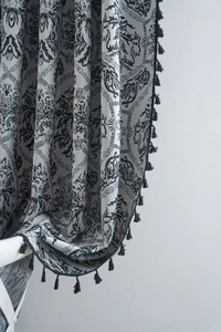 Detail of vintage Baroque damascus jacquard fabric with elegant black tassel fringe