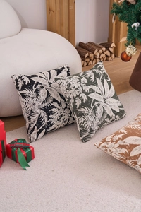 Detail of woven jacquard throw pillow covers with palm leaf patterns in a cozy festive setting