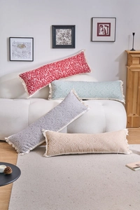 Dettaglio di cuscini lombari in jacquard con motivi damascati e nappine a frange
