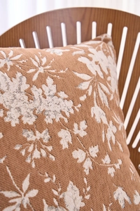 Macro detail of caramel jacquard cushion cover with thick botanical leaf texture pattern