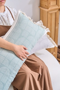 Detail of jacquard lumbar pillow with geometric arc patterns and delicate tassel edges