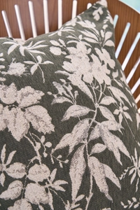 Close-up of dark green chenille jacquard pillow featuring textured beige plant leaf pattern