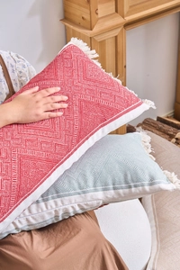 Close-up of bohemian geometric jacquard pillow with white decorative tassels
