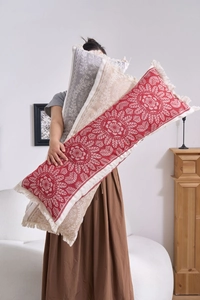 Detail of colorful jacquard bolster pillows with ethnic patterns and white fringe tassels