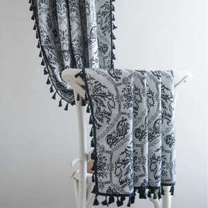 French retro black embossed jacquard curtain with elegant tassels on a white chair
