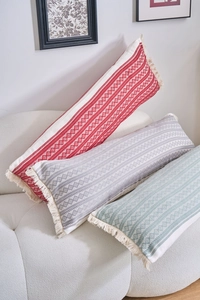 Vue détaillée de coussins lombaires en jacquard tissé avec pompons et motifs géométriques