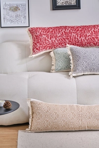Dettaglio di cuscini lombari jacquard colorati con motivi vintage e nappe laterali