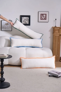 Detailed view of lumbar pillows with colorful wave-knit edges in green, blue and orange
