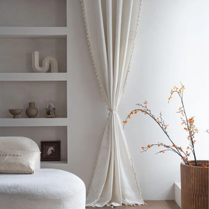 Elegant off-white French jacquard curtain with tassel edges in a cozy home setting
