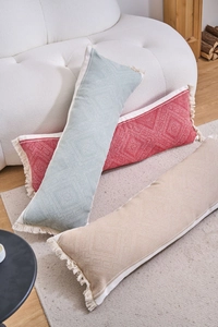 Detail of woven jacquard lumbar pillows with geometric patterns and white fringe trim