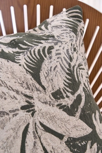 Detailed texture of jacquard chenille pillow with green tropical leaf pattern