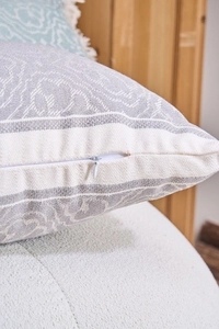 Dettaglio ravvicinato della cerniera invisibile su una fodera per cuscino in jacquard a trama