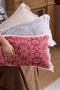Detail of bohemian jacquard pillow covers with fringe tassels in a warm home setting