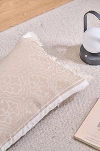 Dettaglio copricuscino jacquard damascato con nappe e cerniera lampo invisibile