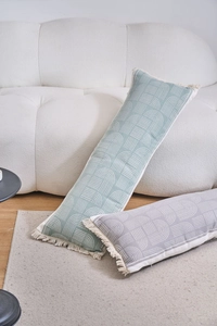 Detailed view of long jacquard lumbar pillows with geometric patterns and fringe edges