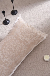 Detail of bohemian jacquard pillow with mandala embroidery and side tassels on rug