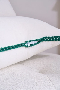 Close-up of beige canvas pillowcase showing green crochet trim and hidden zipper detail