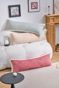 Detail of bohemian jacquard lumbar pillows with tassels in sage green and cream