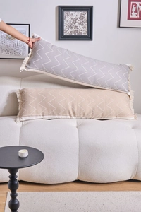 Detail of chevron jacquard lumbar pillows with decorative tassels on a modern sofa