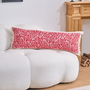 Dettaglio del cuscino lombare jacquard rosso e bianco con frange su divano bianco