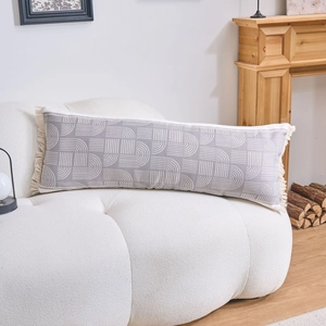 Nordic lumbar pillow with gray geometric patterns and handmade tassels on white sofa