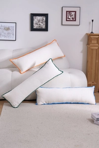 Three rectangular lumbar pillows in cream white with vibrant wavy pom-pom edge trim details