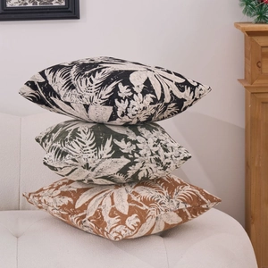 Three premium chenille jacquard square throw pillows with tropical leaf patterns on a sofa
