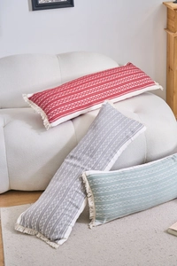 Détails des coussins en jacquard avec motifs géométriques et bordures à franges