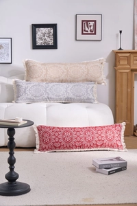 Detail of lumbar pillows with mandala patterns and cream tassels in boho style