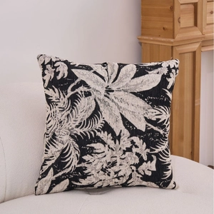 Modern black and white floral chenille jacquard pillow on a white textured sofa
