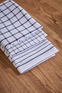 Macro shot of three folded black and white plaid and striped napkins on a wooden table