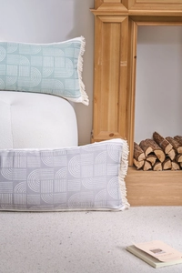 Detail of bohemian cotton weave lumbar pillows with white geometric prints and fringe tassels