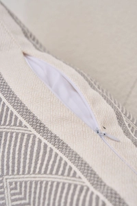 Detailed view of the invisible zipper and woven geometric jacquard texture on the cushion