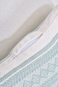 Détail de la fermeture éclair invisible sur la housse de coussin jacquard vert et beige