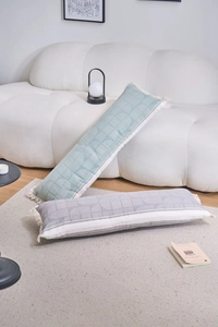 Detail of jacquard lumbar pillows with geometric textures and stylish cream tassels