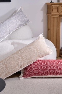 Detail of three bohemian long throw pillows with mandala patterns and tassel edges