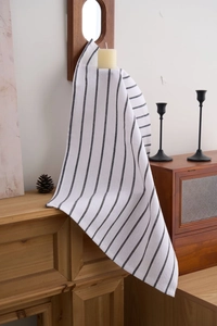 Close-up of black and white striped cotton napkin draped in a rustic home setting