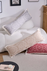 Detail of bohemian long lumbar pillows with mandala patterns and fringe tassels on sofa