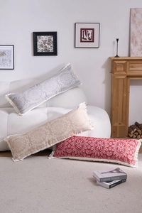Detail of bohemian mandala lumbar pillowcase with decorative cream tassels on sofa