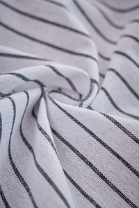 Macro texture of Nordic striped fabric showing fine cotton linen weave and soft folding detail