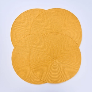 Close-up of four round ginger yellow woven heat resistant PP fiber placemats set