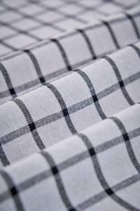 Macro view of black and white checkered fabric with detailed weave and soft cotton texture