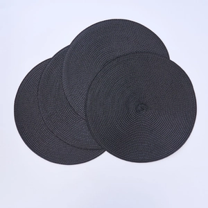 Close-up of four dark grey round woven PP placemats with detailed spiral texture