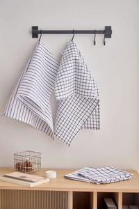 Detail showing hanging black and white striped and checkered cotton napkins on a metal rack